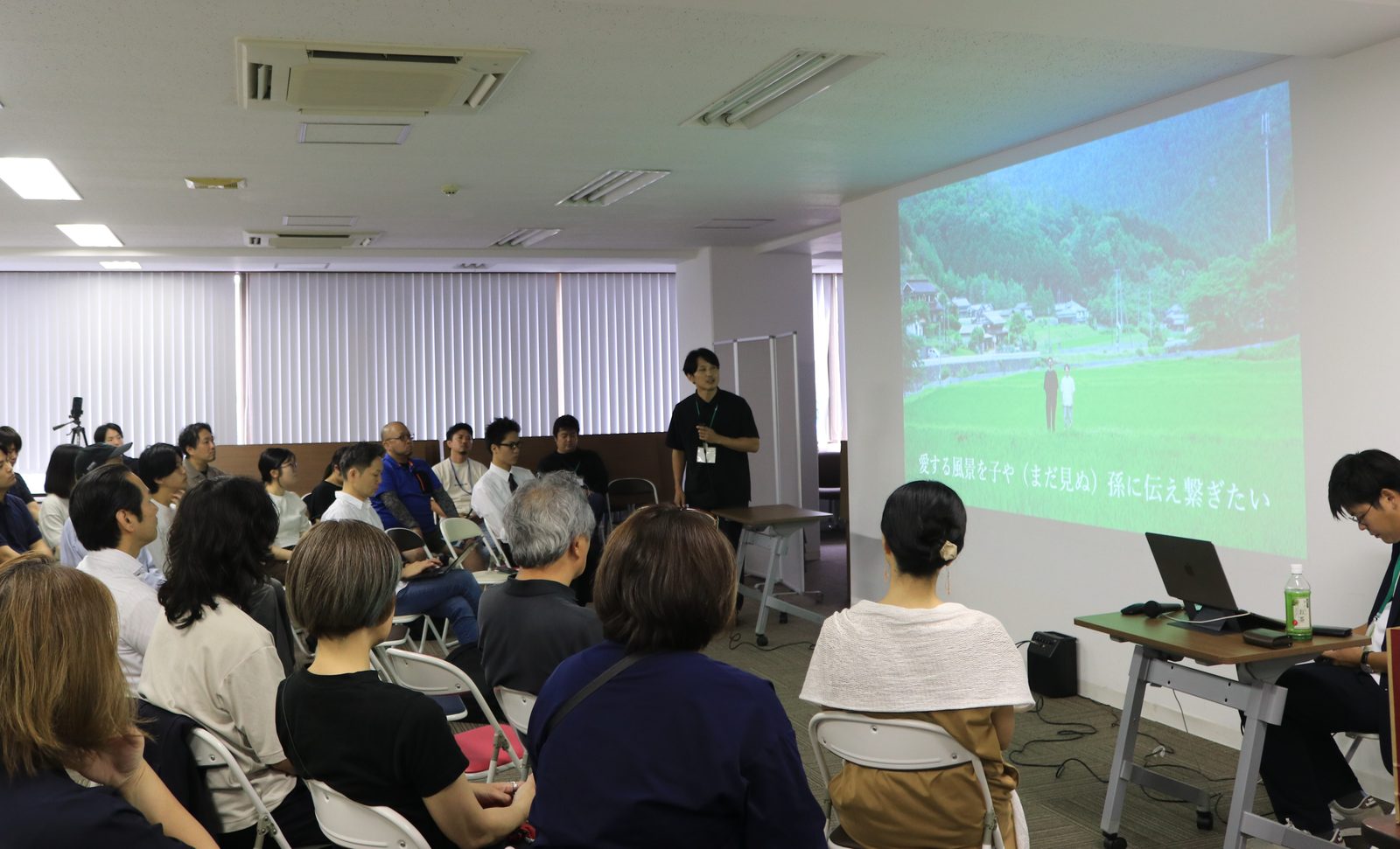 事業者が村の風景スライドを使ってプレゼンテーションする様子